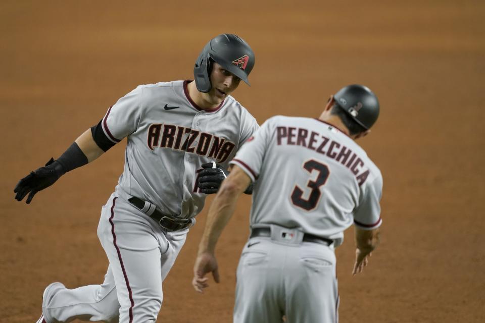 Arizona Diamondbacks' Daulton Varsho, left, celebrates his solo home run with third base coach Tony Perezchica during the eighth inning of a baseball game against the Texas Rangers in Arlington, Texas, Wednesday, July 28, 2021. (AP Photo/Tony Gutierrez)