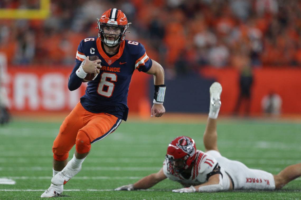 Syracuse quarterback Garrett Shrader (6) evades a tackle by North Carolina State linebacker Payton Wilson (11) during the second half of an NCAA college football game Saturday, Oct. 15, 2022, in Syracuse, N.Y.