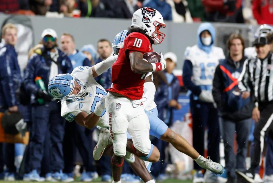 N.C. State wide receiver KC Concepcion (10) sheds North Carolina defensive back Will Hardy (31) during the first half of N.C. State’s game against UNC at Carter-Finley Stadium in Raleigh, N.C., Saturday, Nov. 25, 2023.