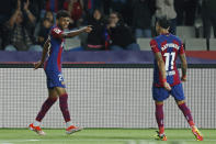 Barcelona's Lamine Yamal, left, celebrates with Raphinha after scoring the opening goal during a Spanish La Liga soccer match between Barcelona and Real Sociedad at the Olimpic Lluis Companys stadium in Barcelona, Spain, Monday, May 13, 2024. (AP Photo/Joan Monfort)