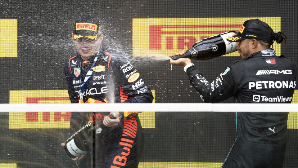 Winner Red Bull Racing's Max Verstappen, of the Netherlands, is sprayed with champagne by third place finisher Mercedes driver Lewis Hamilton, of the United Kingdom, during victory ceremonies following the Formula One Canadian Grand Prix auto race, Sunday, July 18, 2023, in Montreal. (Paul Chiasson/The Canadian Press via AP)