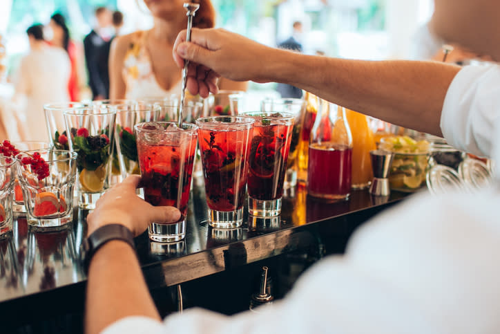 Bartender preparing a selection of fruit garnished drinks at a wedding reception