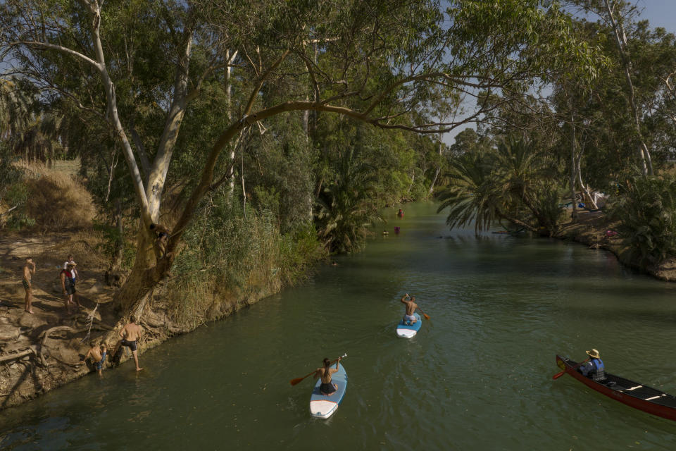 People spend the day at the Jordan River near Kibbutz Kinneret in northern Israel on Saturday, July 30, 2022. Only a tiny fraction of the river’s historical water flow now reaches its terminus in the Dead Sea. (AP Photo/Oded Balilty)