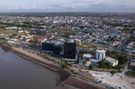 The Pegasus Suites and Corporate Centre, center, which expands the original Pegasus hotel, right, and adds new commercial spaces, stands tall on the delta of the Demerara River and Atlantic Coast, in Georgetown, Guyana, Wednesday, April 12, 2023. Guyana was once known as the “Venice of the West Indies” and in the capital, buildings made of glass, steel and concrete rise above colonial-era wooden structures that are slowly decaying. (AP Photo/Matias Delacroix)