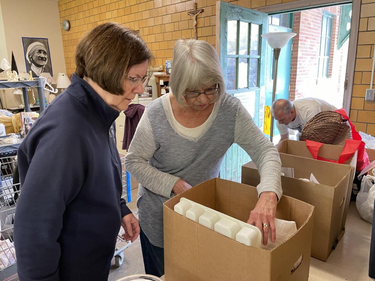 In the Spirit of Giving volunteers Lorie Bronson (left) and Gwen Marlow look through kitchen items donated by Ileene Smith.