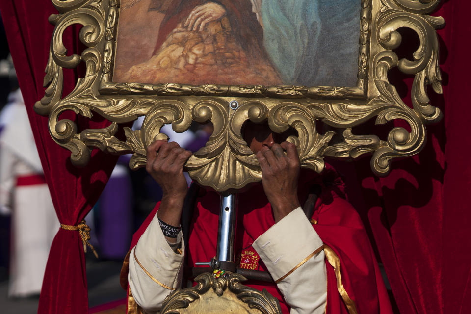 A penitent holds a religious symbol during a Holy Week procession in Antigua, Guatemala, on Good Friday, March 29, 2024. (AP Photo/Moises Castillo)