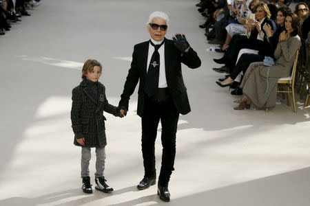 German designer Karl Lagerfeld and model Hudson Kroenig appear at the end of his Fall/Winter 2016/2017 women's ready-to-wear collection for fashion house Chanel at the Grand Palais in Paris, France, March 8, 2016. REUTERS/Gonzalo Fuentes