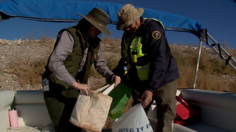 <em>National Park Ranger Anna Blalock and volunteer Ken Kotora examine trash collected from a Lake Mead beach. (KLAS)</em>