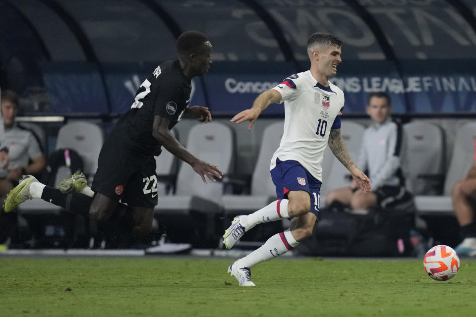 Christian Pulisic of the United States attempts to drive by Richmond Laryea, of Canada, during the first half of a CONCACAF Nations League final match Sunday, June 18, 2023, in Las Vegas. (AP Photo/John Locher)