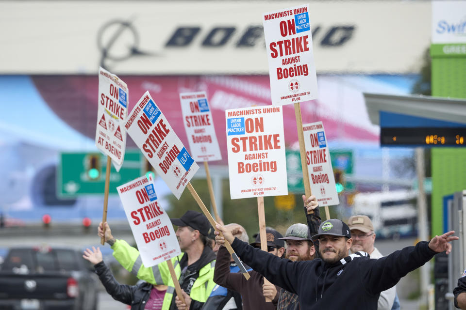 Boeing Machinists Union member Nico Padilla, front, and others wave to passing traffic on the picket line at the Everett plant, Friday, Sept. 13, 2024, in Everett, Wash. (AP Photo/John Froschauer)