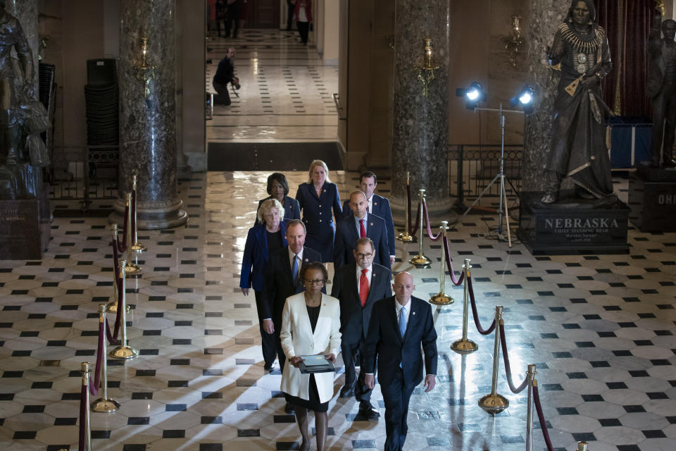 Clerk of the House Cheryl Johnson, left, and House Sergeant at Arms Paul Irving pass through Statuary Hall at the Capitol to deliver the articles of impeachment against President Donald Trump to the Senate, on Capitol Hill in Washington, Wednesday, Jan. 15, 2020. Following are impeachment managers, House Intelligence Committee Chairman Adam Schiff, D-Calif., left, and House Judiciary Committee Chairman Jerrold Nadler, D-N.Y., and other managers Rep. Hakeem Jeffries, D-N.Y., Rep. Sylvia Garcia, D-Texas, Rep. Val Demings, D-Fla., Rep. Zoe Lofgren, D-Calif., and Rep. Jason Crow, D-Colo. (AP Photo/J. Scott Applewhite)