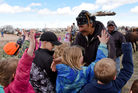 Roderick Dupris, 45, from Bridger on the Cheyenne River Reservation shakes hands with students at the public school adjacent to the Wall rodeo grounds where the riders have their camp in Wall, South Dakota, U.S., April 18, 2018. REUTERS/Stephanie Keith