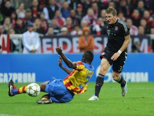 Bayern Munich's midfielder Bastian Schweinsteiger (R) scores past Valencia's defender Aly Cissokho during their UEFA Champions League group F football match in the southern German city of Munich. Bayern won 2-1