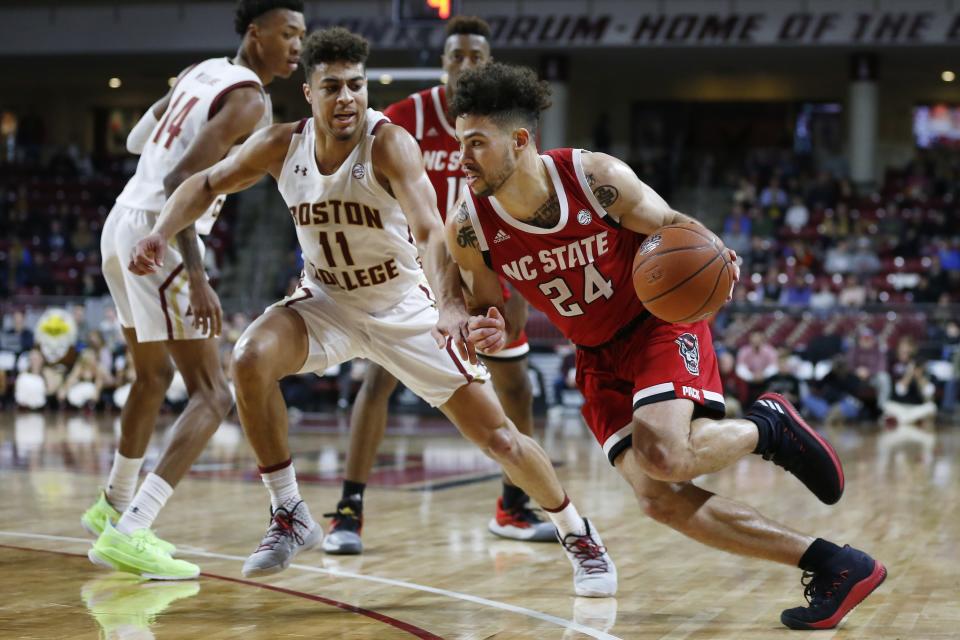 North Carolina State's Devon Daniels (24) drives past Boston College's Derryck Thornton (11) during the second half of an NCAA college basketball game in Boston, Sunday, Feb. 16, 2020. (AP Photo/Michael Dwyer)