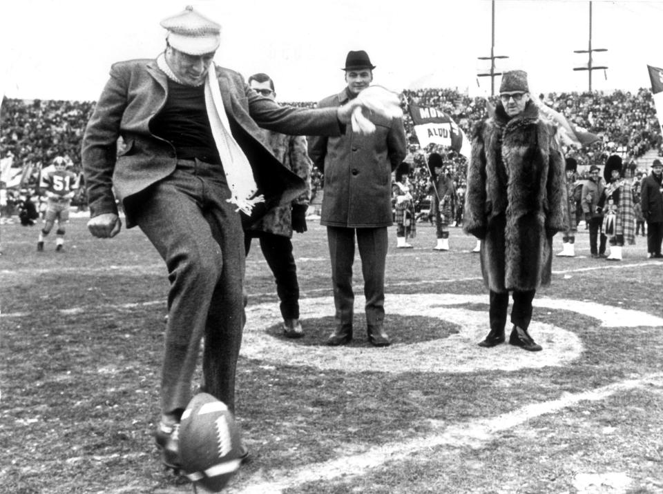 Prime Minister Pierre Trudeau kicks off the 1969 Grey Cup game, watched by Montreal Mayor Jean Drapeau. (The Globe and Mail/The Canadian Press)