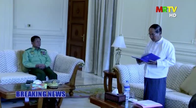 A screen grab from Myanmar state television footage, broadcast on February 1, 2021, shows Myanmar Acting President Myint Swe (R) reading a statement, as General Min Aung Hlaing (L) looks on