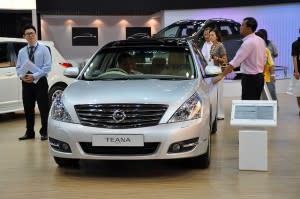 Car in showroom, with man behind the wheel