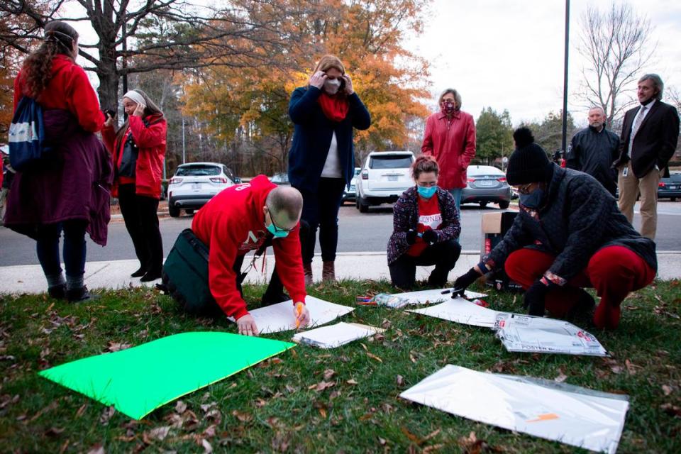 Some members of NCAE make signs before a rally outside the Wake County School Board meeting in Cary, N.C. on Tuesday, Dec. 7, 2021.