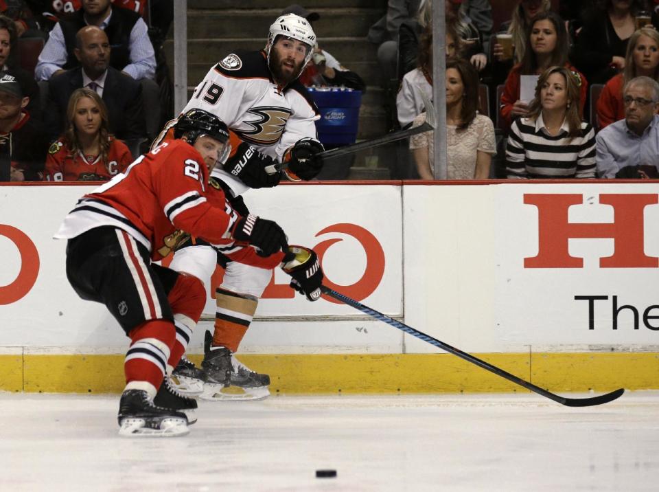 Anaheim Ducks left wing Patrick Maroon (19) passes off the puck against Chicago Blackhawks right wing Kris Versteeg (23) during the first period of Game 3 of the Western Conference finals in the NHL hockey Stanley Cup playoffs, Thursday, May 21, 2015, in Chicago. (AP Photo/Nam Y. Huh)