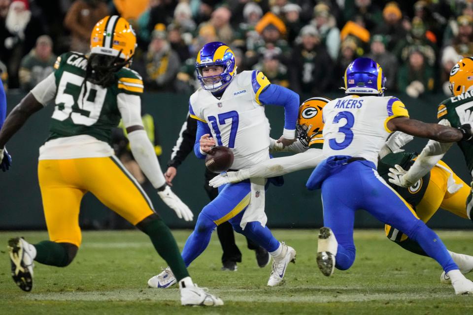 Los angles Rams quarterback Baker Mayfield (17) fumbles as he's hit by Green Bay Packers linebacker Quay Walker (7) in the first half of an NFL football game in Green Bay, Wis. Monday, Dec. 19, 2022. Rams recovered the ball. (AP Photo/Morry Gash)