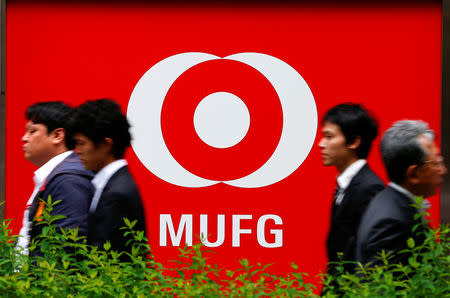 FILE PHOTO - People walk past a branch of Mitsubishi UFJ Financial Group's bank of Tokyo-Mitsubishi UFJ (MUFG) in Tokyo, Japan, May 16, 2016. REUTERS/Thomas Peter/File Photo