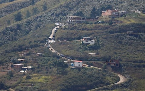 Police vehicles seen lining a street during a shootout between security forces and rogue Venezuelan helicopter pilot Oscar Perez - Credit:  MARCO BELLO/ REUTERS