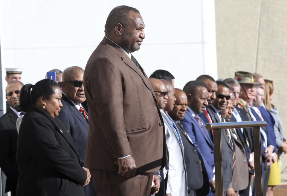 Papua New Guinea Prime Minister James Marape stands on a podium before inspecting troops as he is officially welcomed to Australia's Parliament House in Canberra Monday, July 22, 2019. Marape says his country's relationship with China in not open to discussion during his current visit to Australia. (AP Photograph/Rod McGuirk)