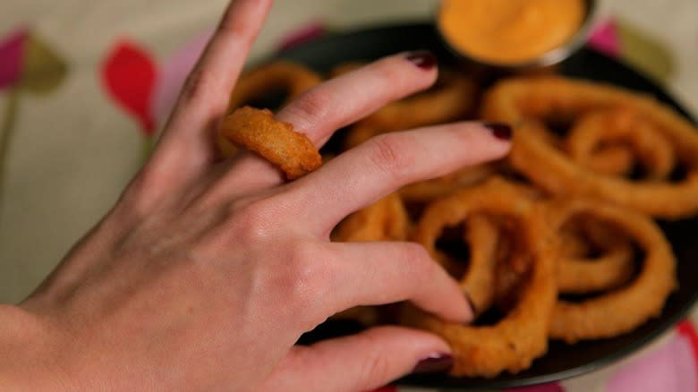 Onion Rings on plate and finger