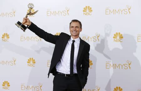 Phil Keoghan poses with his Outstanding Reality-Competition Program award for the CBS show "The Amazing Race" at the 66th Primetime Emmy Awards in Los Angeles, California August 25, 2014. REUTERS/Mike Blake (UNITED STATES -Tags: ENTERTAINMENT)(EMMYS-BACKSTAGE)