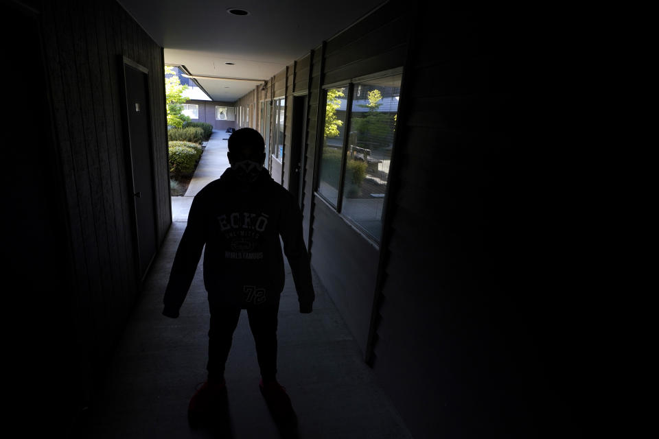 "D.Y.," a teenager who is currently living in a foster-care group home, poses for a photo Friday, May 21, 2021, at the facility's administrative office in University Place, Wash. D.Y., who is not being named by the Associated Press to protect his identity, is currently suing the Washington State Department of Children, Youth and Families, alleging that the state has provided inadequate care after bouncing him through more than 50 placements before the COVID-19 pandemic. An Associated Press analysis of state data reveals that the coronavirus pandemic has destabilized the foster care system, leaving children with no parental visits, unprecedented delays in family court cases and limited access to services demanded for reunification. (AP Photo/Ted S. Warren)