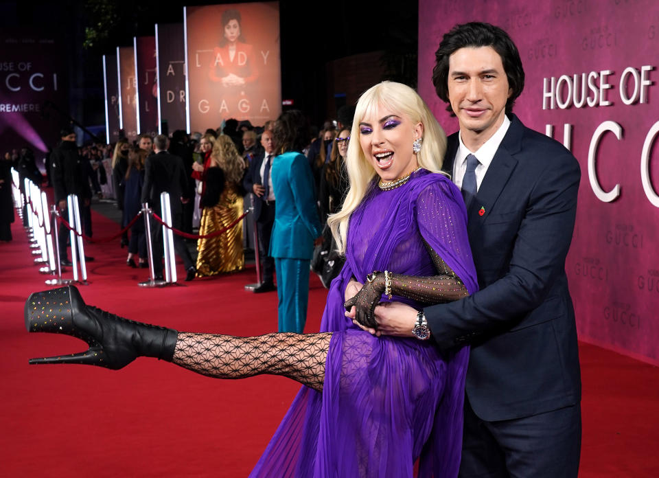 Gaga being hugged by Adam Driver and kicking up her platform heel