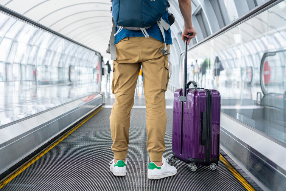 A Traveler walking on moving walkway in the airport