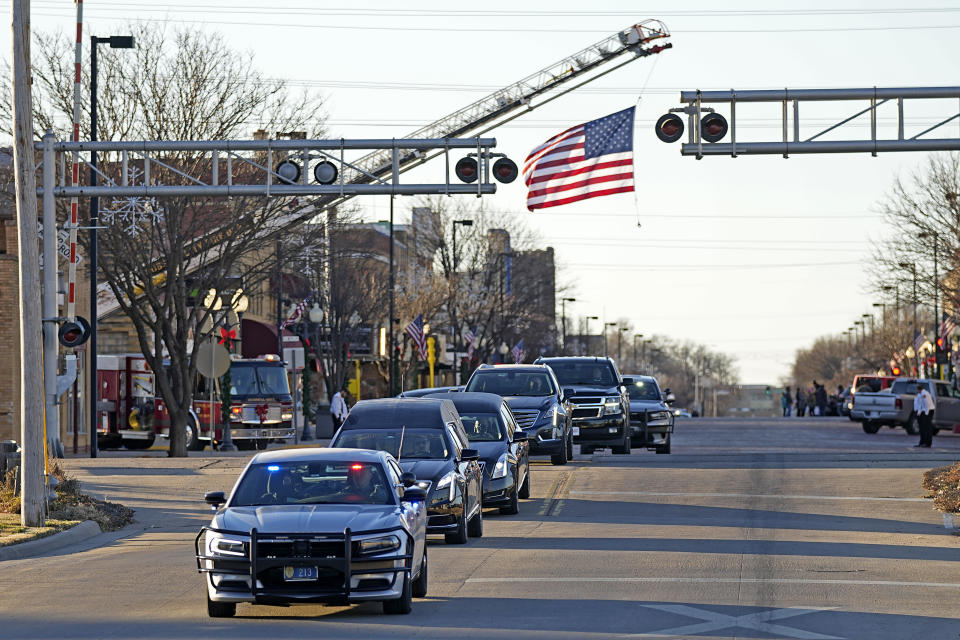 A hearse carries the casket holding former Sen. Bob Dole, R-Kan., down Main Street on the way to a memorial service Saturday, Dec. 11, 2021, in Russell, Kan. (AP Photo/Charlie Riedel)