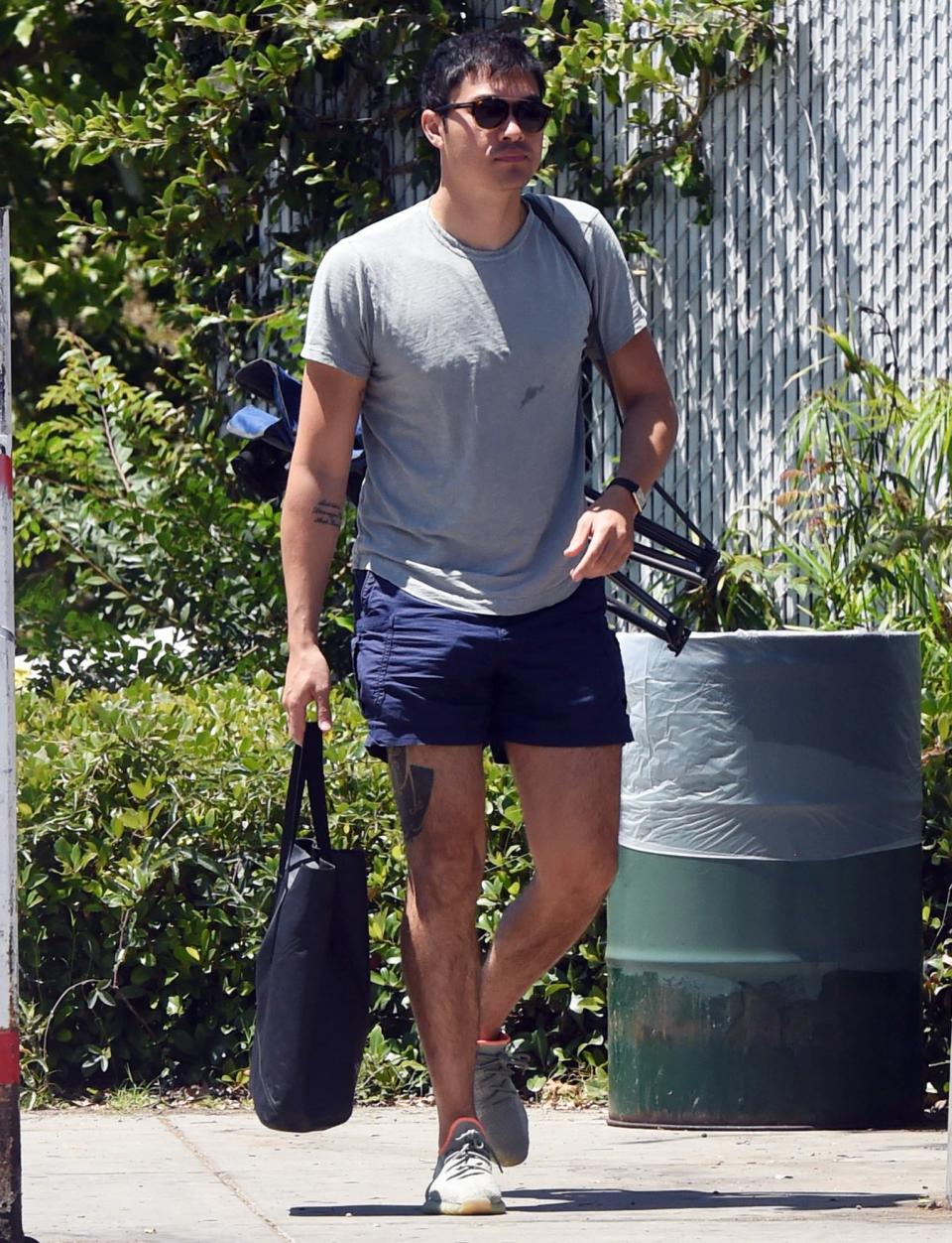 <p>A solo Henry Golding totes his chair and bag for a picnic in a Los Angeles park on Sunday.</p>