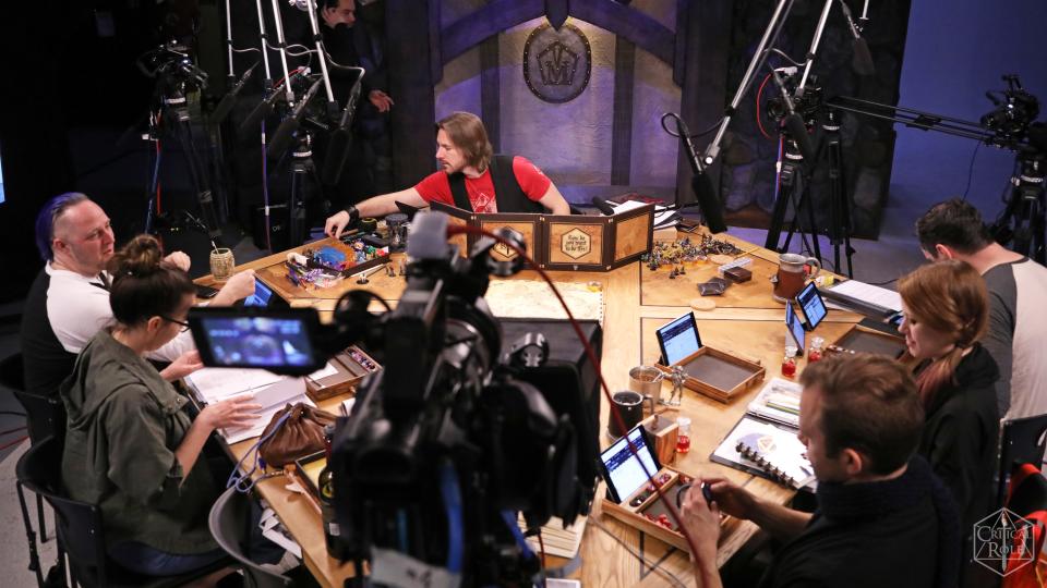 A top shot of the cast of Critical Role in their studio, with game master Matthew Mercer in the center. 