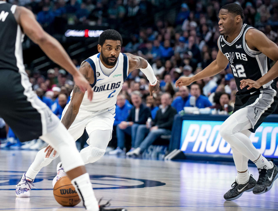 ARCHIVO - Foto del 23 de febrero del 2023, el base de los Mavericks de Dallas Kyrie Irving avanza con el balón superando a Malaki Branham de los Spurs de San Antonio. (AP Foto/Emil T. Lippe, Archivo)