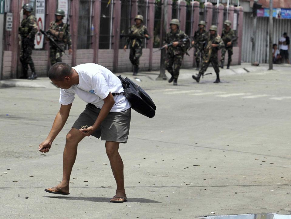 A man picks up bullet casings after Muslim rebels members of the Moro National Liberation Front (MNLF) clashed with government soldiers in Zamboanga city