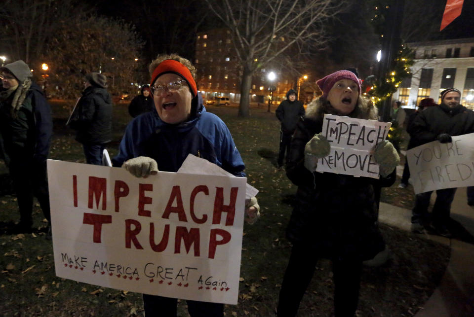 Barb Callahan (left), of Guttenberg, Iowa, and Joey Zelinskas, of Dubuque, chant during the "Nobody Is Above the Law" impeachment rally at Washington Square in Dubuque on Tuesday, Dec. 17, 2019. (Eileen Meslar/Telegraph Herald via AP)