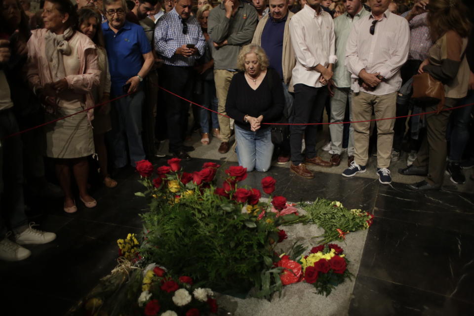 In this Saturday, Oct. 5, 2019 photo, people visit the tomb of former Spanish dictator Francisco Franco inside the basilica at the Valley of the Fallen monument near El Escorial, outside Madrid. After a tortuous judicial and public relations battle, Spain's Socialist government has announced that Gen. Francisco Franco's embalmed body will be relocated from a controversial shrine to a small public cemetery where the former dictator's remains will lie along his deceased wife. (AP Photo/Alfonso Ruiz)