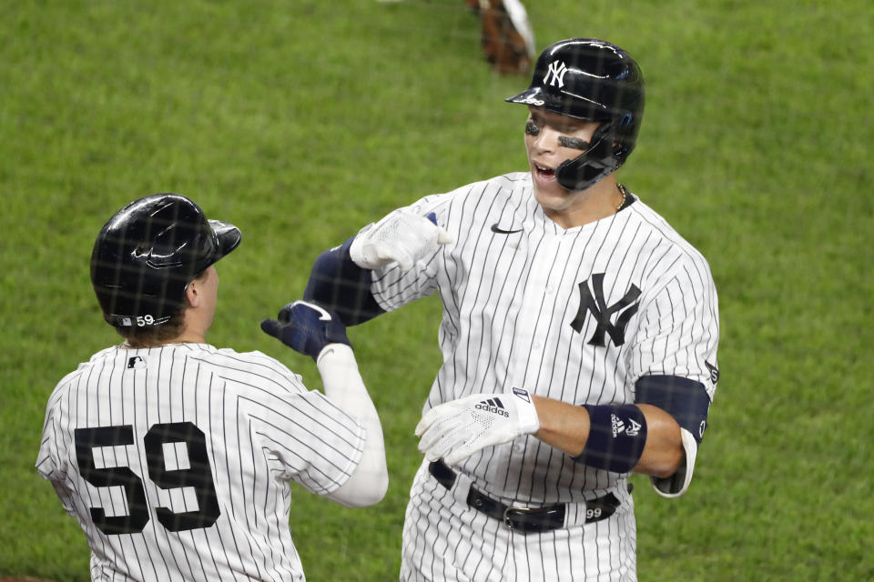 New York Yankees Aaron Judge, right, celebrates with the Yankees Luke Voit (59) after hitting a solo home run during the fifth inning of a baseball game against the Atlanta Braves, Tuesday, Aug. 11, 2020, in New York. (AP Photo/Kathy Willens)