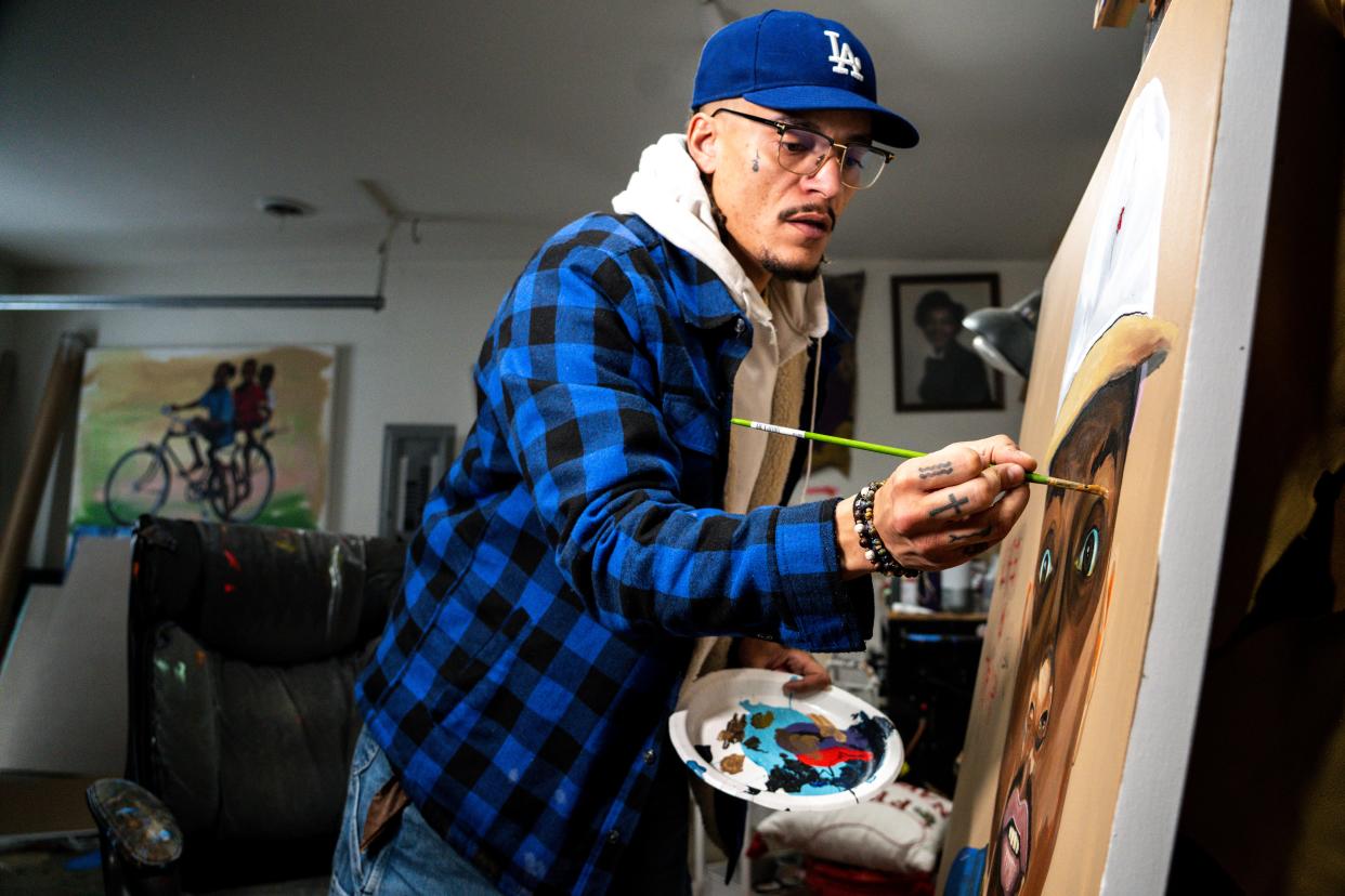 Robert Moore touches up a self-portrait in his home studio.