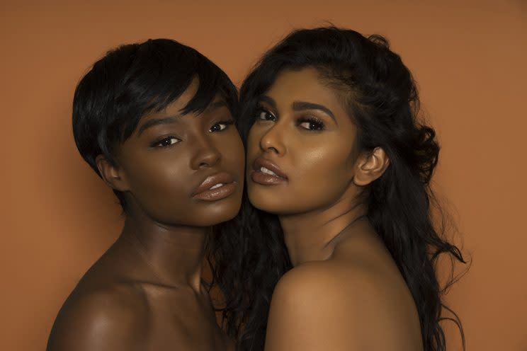 Two black women wearing nude lipstick pose, cheek to cheek.