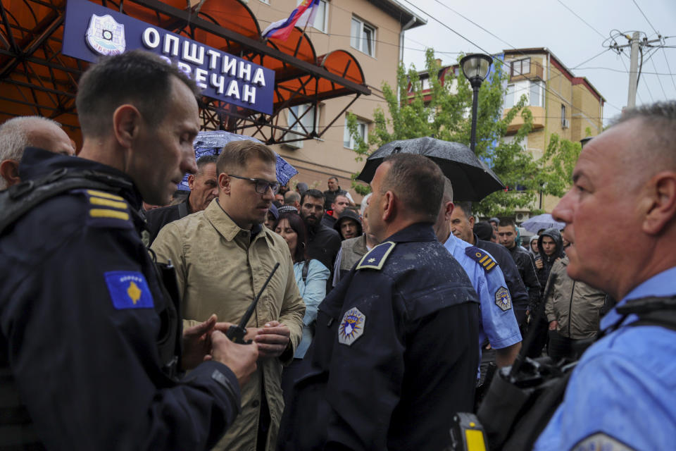 Aleksandar Arsenijevic, local politician, talks to police officers in the town of Zvecan, Kosovo, Friday, May 26, 2023. Small groups of ethnic Serbs in northern Kosovo on Friday clashed with police while trying to block the entrance of municipal buildings to prevent recently-elected officials from entering them, according to local media. (AP Photo/Bojan Slavkovic)
