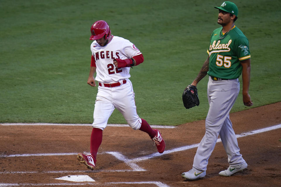 Los Angeles Angels' David Fletcher, left, scores on a wild pitch by Oakland Athletics starting pitcher Sean Manaea, right, during the first inning of a baseball game, Monday, Aug. 10, 2020, in Anaheim, Calif. (AP Photo/Jae C. Hong)