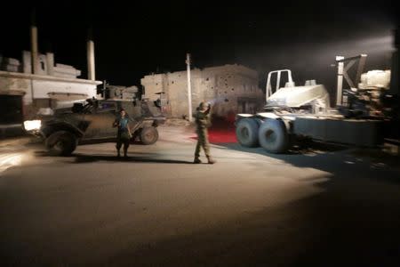 A Turkish soldier (R) walks near a rebel fighter (L) near Turkish Army vehicles in northern Aleppo countryside, Syria September 29, 2016. Picture taken September 29, 2016. REUTERS/Khalil Ashawi