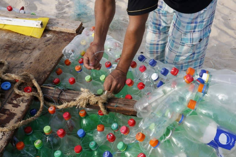 Palestinian fisherman Mouad Abu Zeid adjusts his boat, made of 700 empty plastic bottles, which he uses to catch sardines, mullet and other small fish