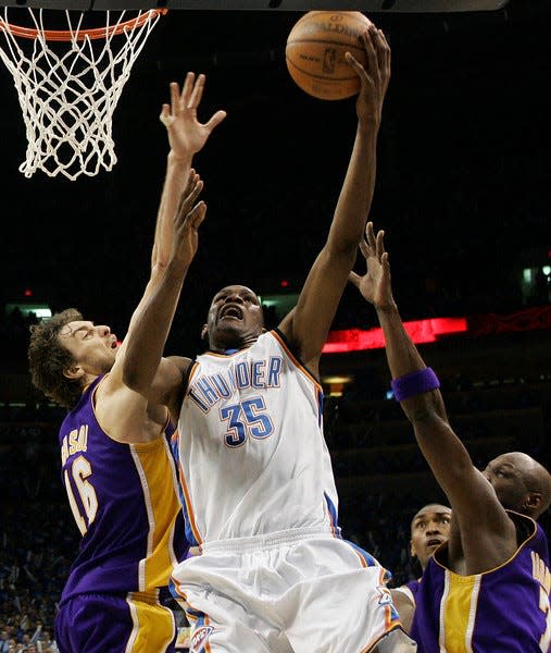 FILE - This April 30, 2010, file photo shows Oklahoma City Thunder forward Kevin Durant, center, shooting between Los Angeles Lakers forward Pau Gasol, left, of Spain, and forward Lamar Odom, right, in the fourth quarter of Game 6 of a first-round NBA basketball playoff series, in Oklahoma City. All Durant did last season was become the youngest scoring champion in NBA history, take the Thunder to the playoffs for the first time since they moved to Oklahoma City and lead the U.S. to a gold medal at the world championships. (AP Photo/Sue Ogrocki, File)