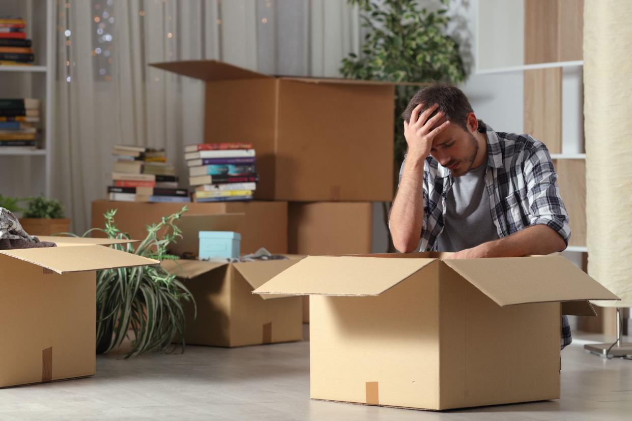 Sad evicted man moving home complaining on the floor