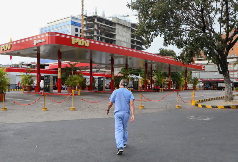 A doctor walks near a closed gas station during the nationwide quarantine due to the coronavirus disease (COVID-19) outbreak, in Caracas