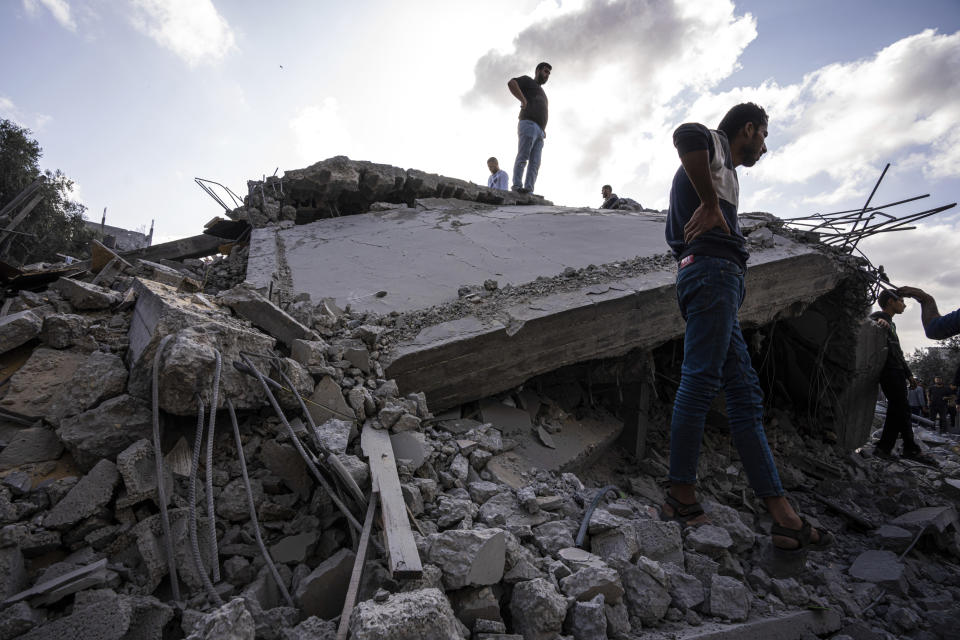 Palestinians inspect the rubble at the site of an airstrike that the Israeli military said targeted the house of an Islamic Jihad member, in Deir al-Balah, central Gaza Strip, Saturday, May 13, 2023. (AP Photo/Fatima Shbair)